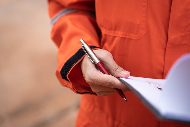 worker with a pen and checklist on a clipboard running an effects analysis 