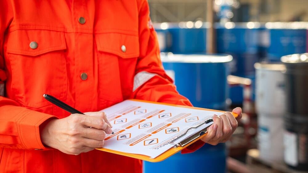 worker with a safety data sheet taking safety precautions in facility maintenance