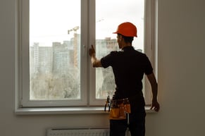 man performing preventive maintenance on a window frame