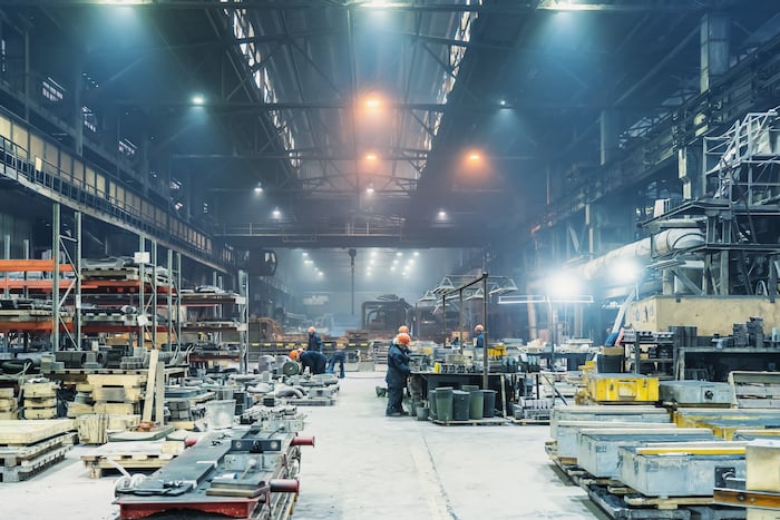 A picture of a factory with machines and workers, illustrating the concept of Total Productive Maintenance