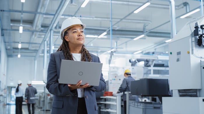 A picture of a factory with machines and workers, illustrating the concept of Common Challenges and Solutions