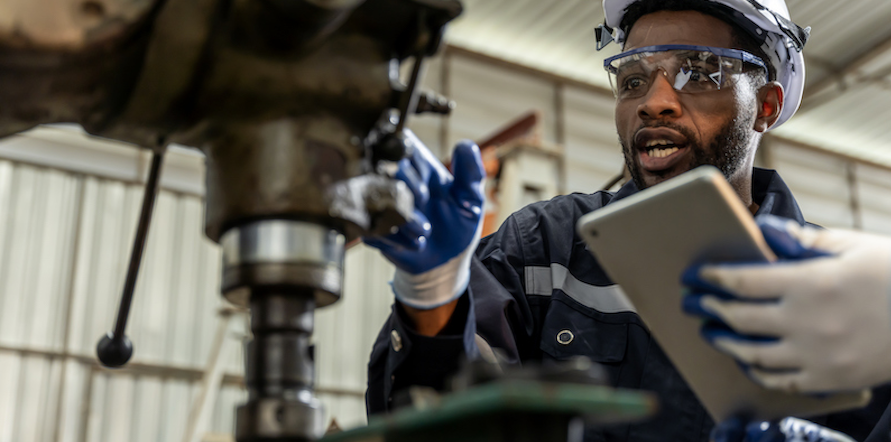 A picture of a maintenance manager looking at a computer screen with asset maintenance data